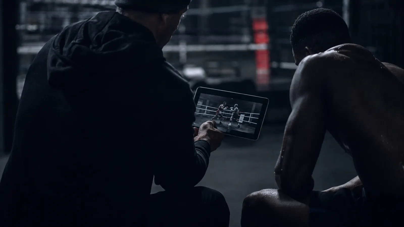 Coach analysant une vidéo de combat sur tablette avec son athlète